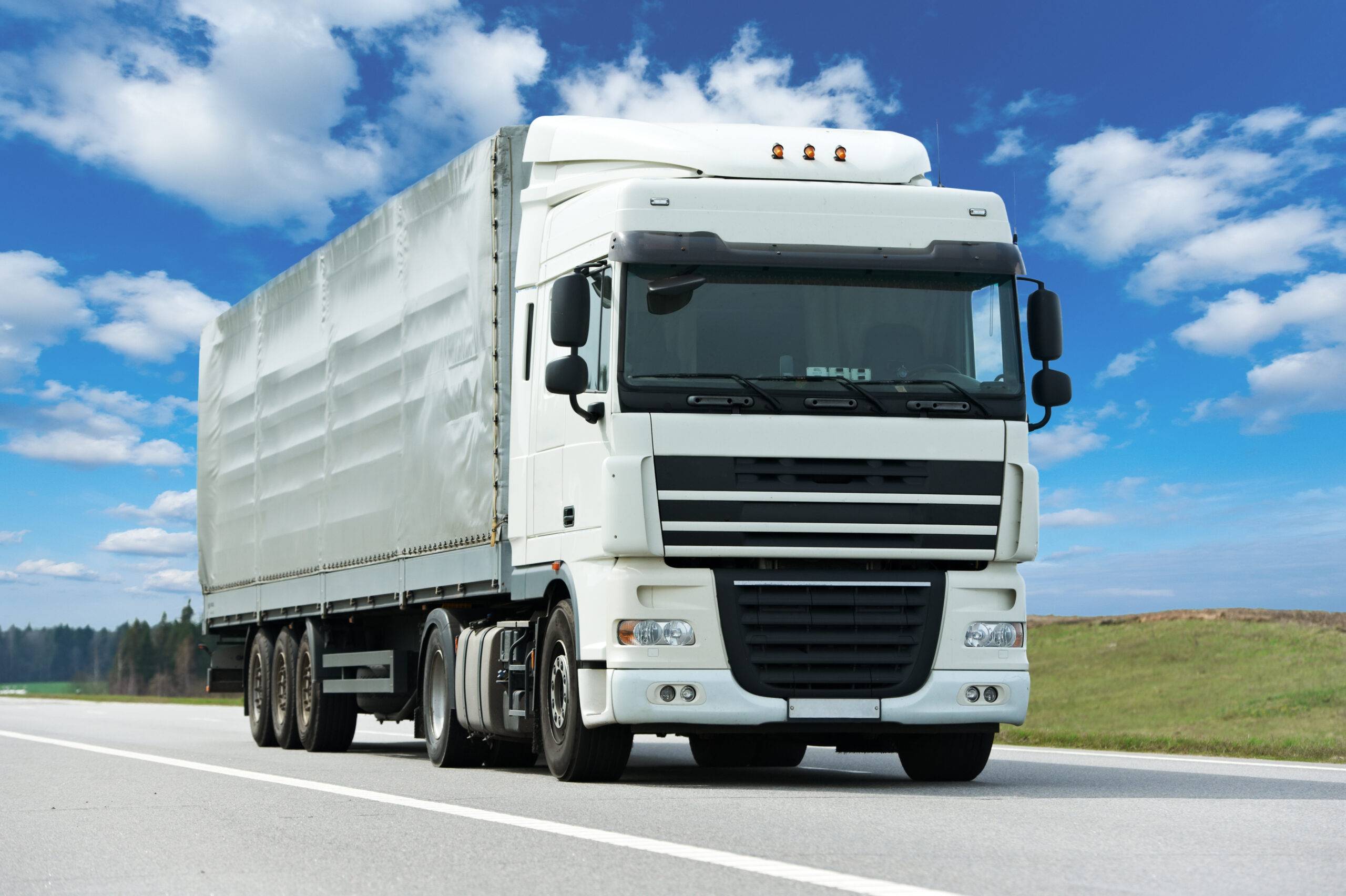 White Lorry With Grey Trailer Over Blue Sky