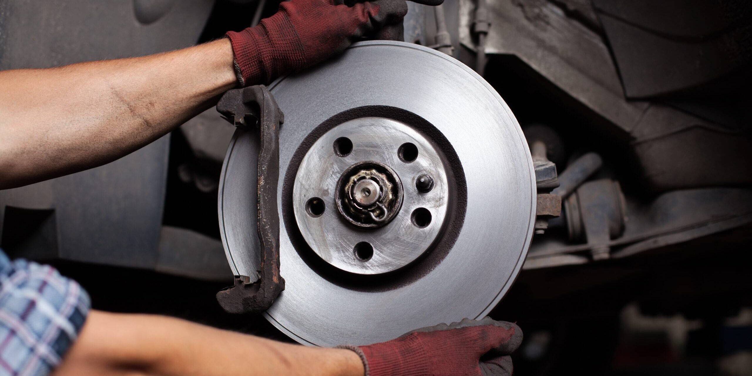 Car Mechanic Repairing Brakes On Car